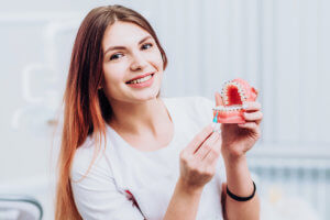 a young woman demonstrates caring for your braces